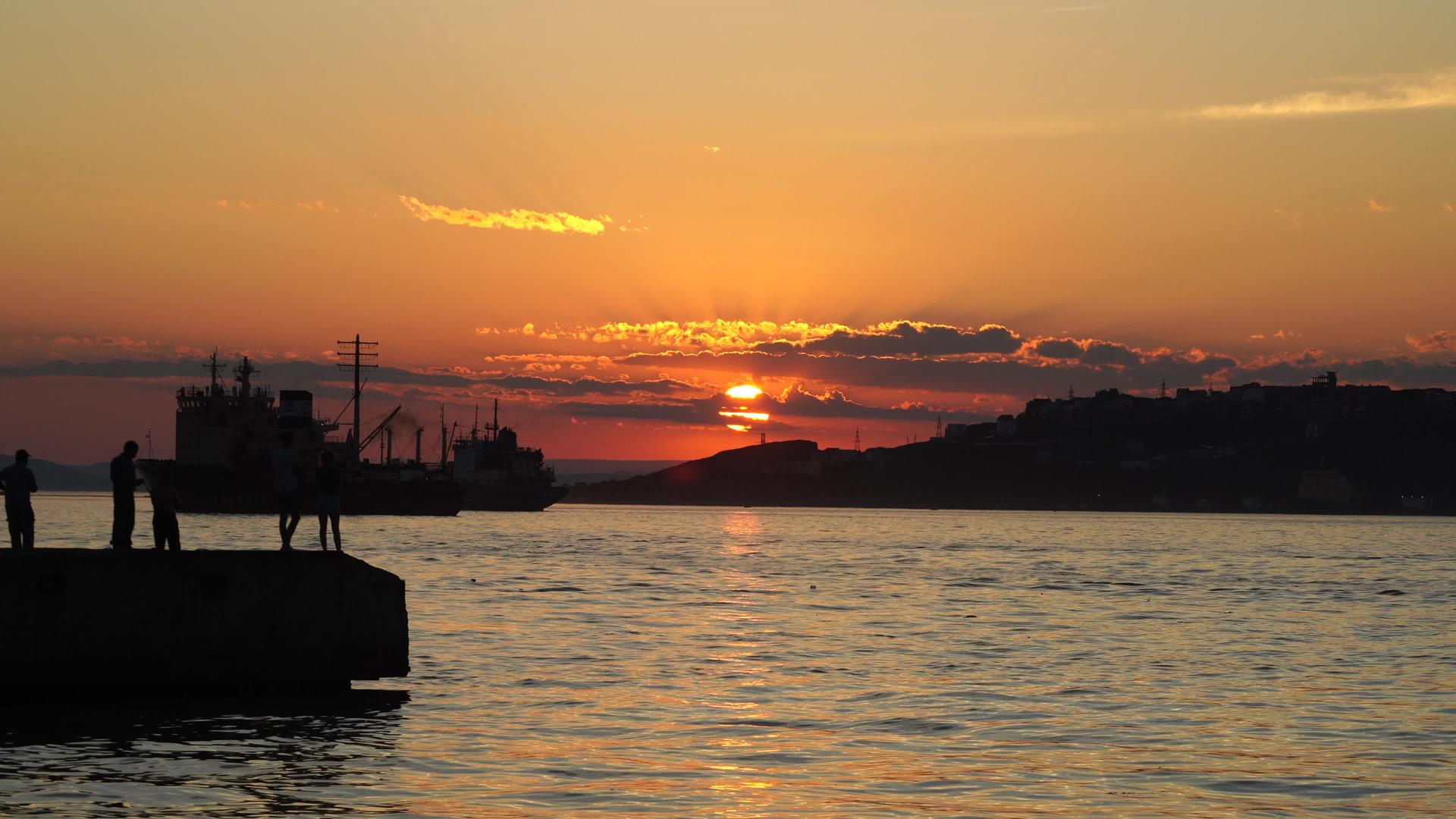 日落时分渔民和一艘船环绕着俄罗斯的海景视频的预览图