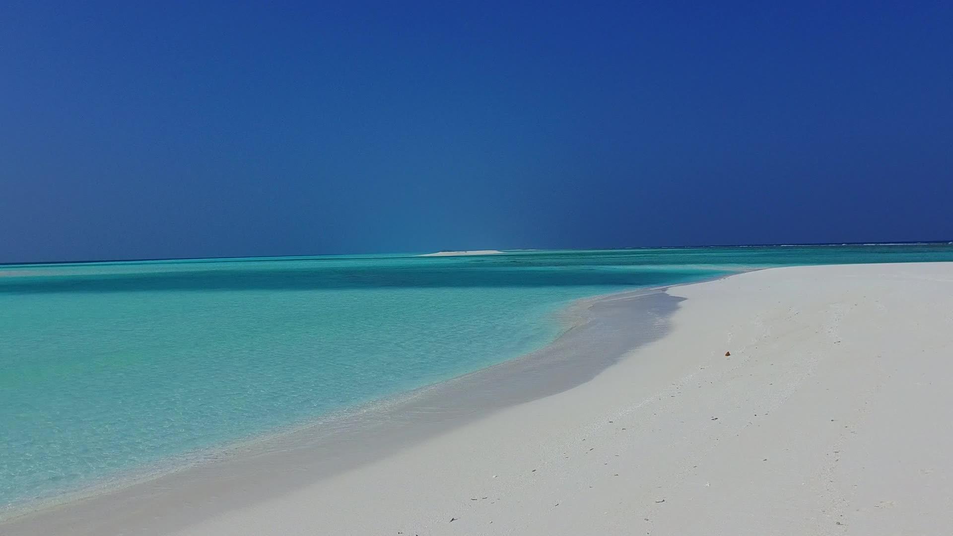 在阳光下蓝色的海洋和明亮的沙质背景被用来复制宁静的度假海滩视频的预览图