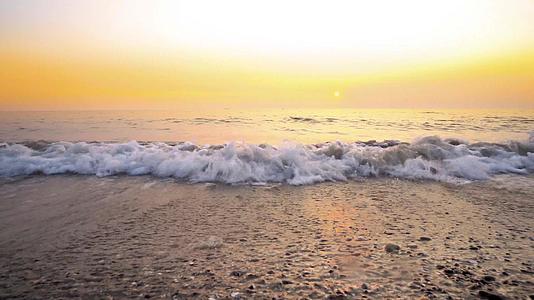 海浪在海滩上与日落相撞海滩的背景视频的预览图
