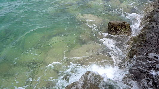 海浪喷洒在混凝土楼梯和岩石码头上视频的预览图