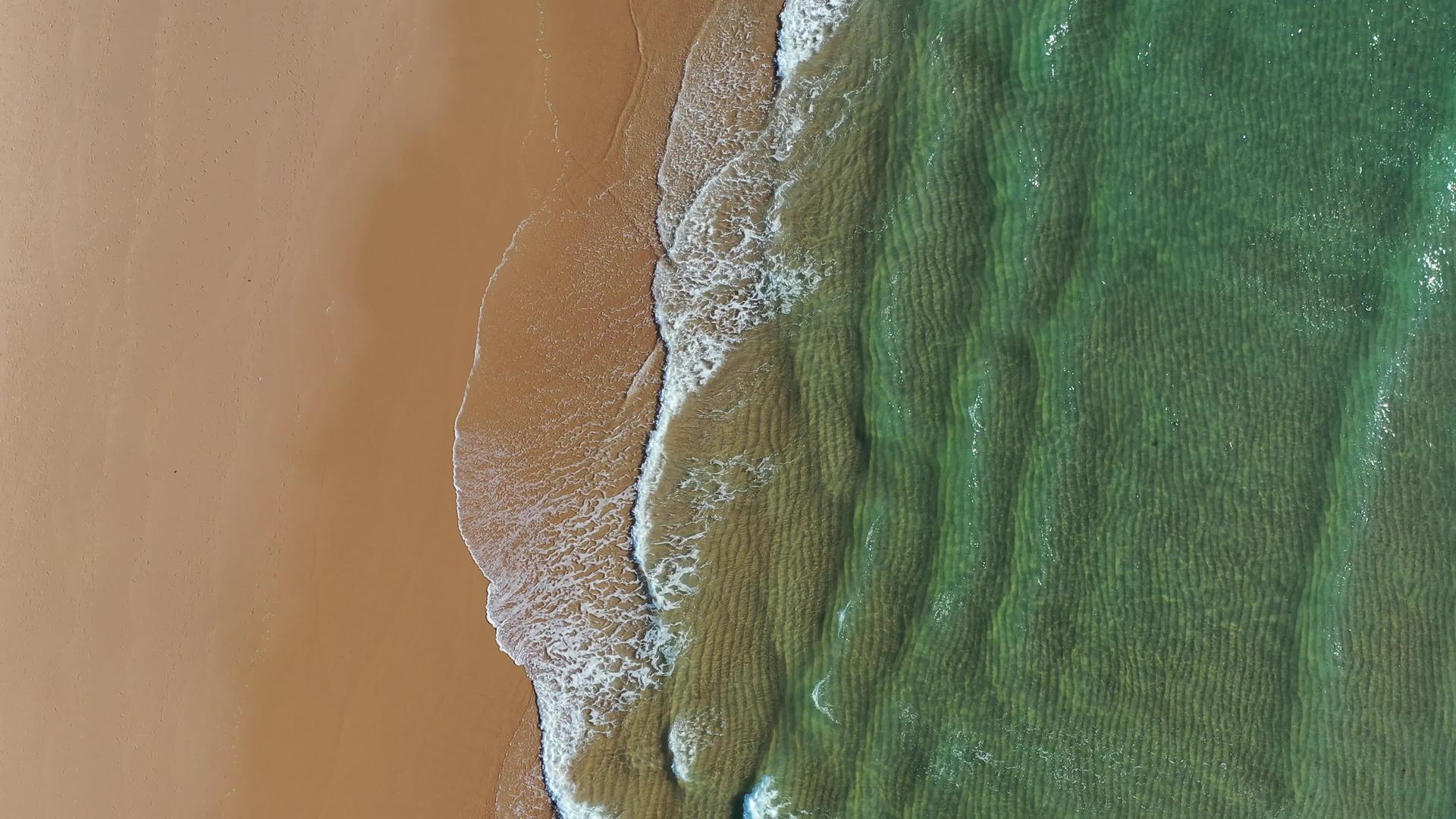 热带海滩鸟瞰图热带黄色海滩上的波浪顶部视频的预览图
