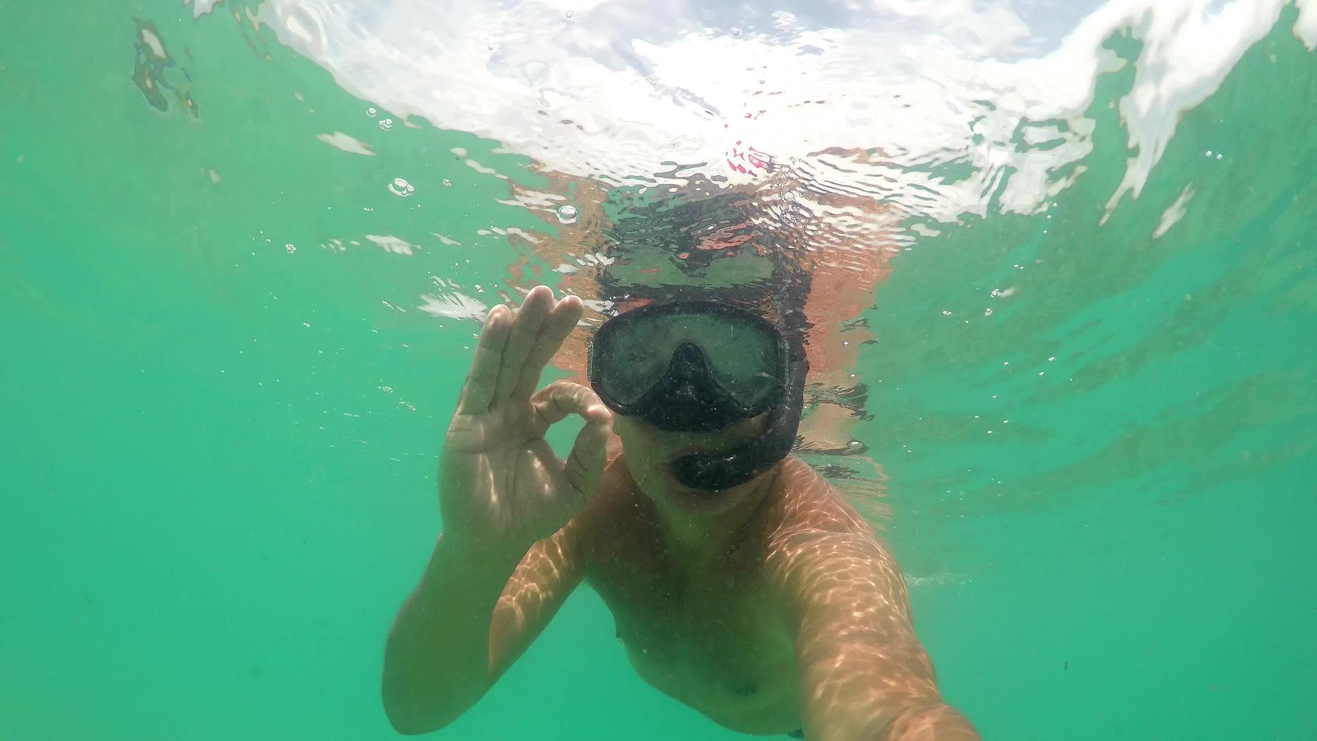 戴着面具在海上潜水用手指举起手势标志的胸罩和佩佩特视频的预览图