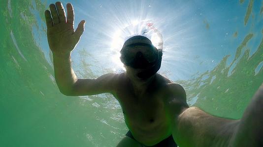 潜水员在夏天的阳光下挥舞着潜水面罩视频的预览图