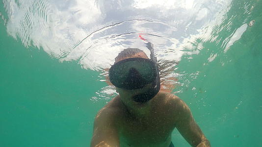 一名男子戴着面具在海上潜水挥舞着相机视频的预览图