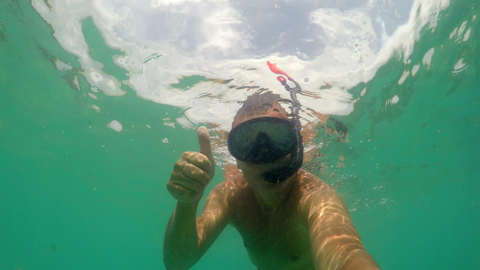 戴着面具在海里潜水用手指示滑行的男子的手势标志视频的预览图