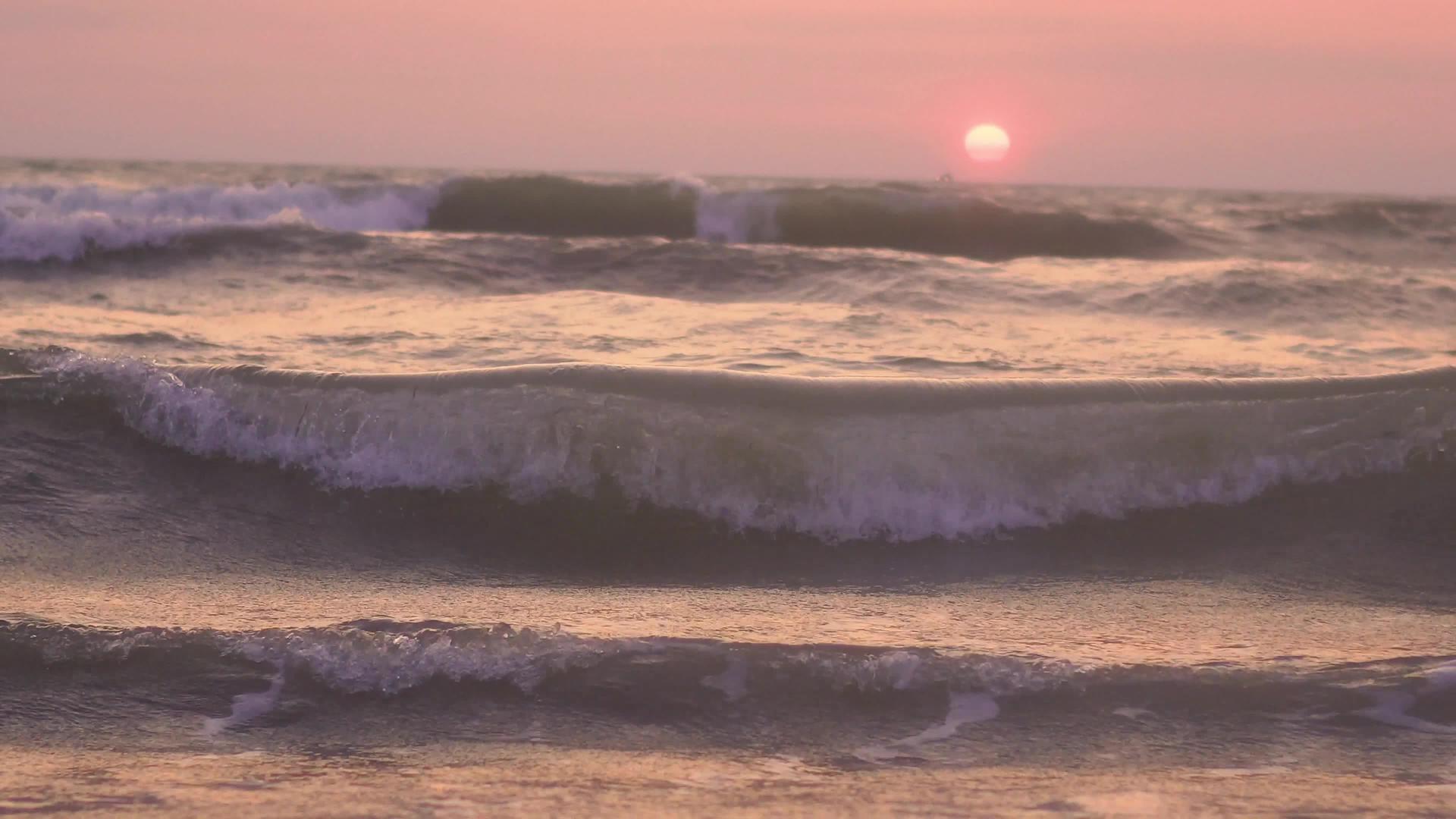 日落时海滩上的金色沙滩被冲走了视频的预览图