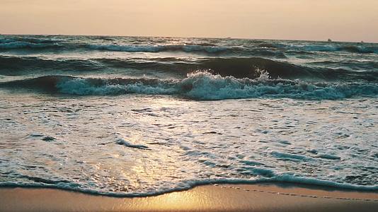 海滩上日落时的波浪视频的预览图