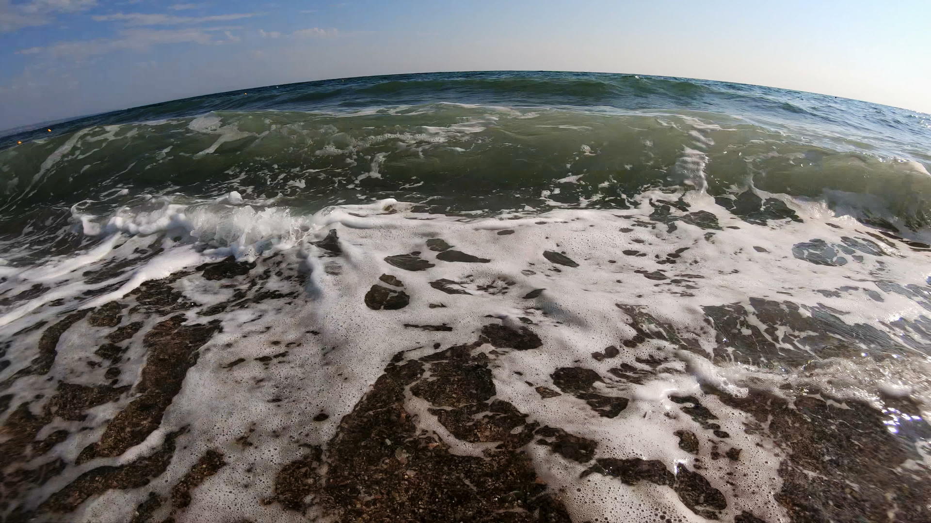 在阳光明媚的夏日海浪在岸边慢慢地冲浪视频的预览图