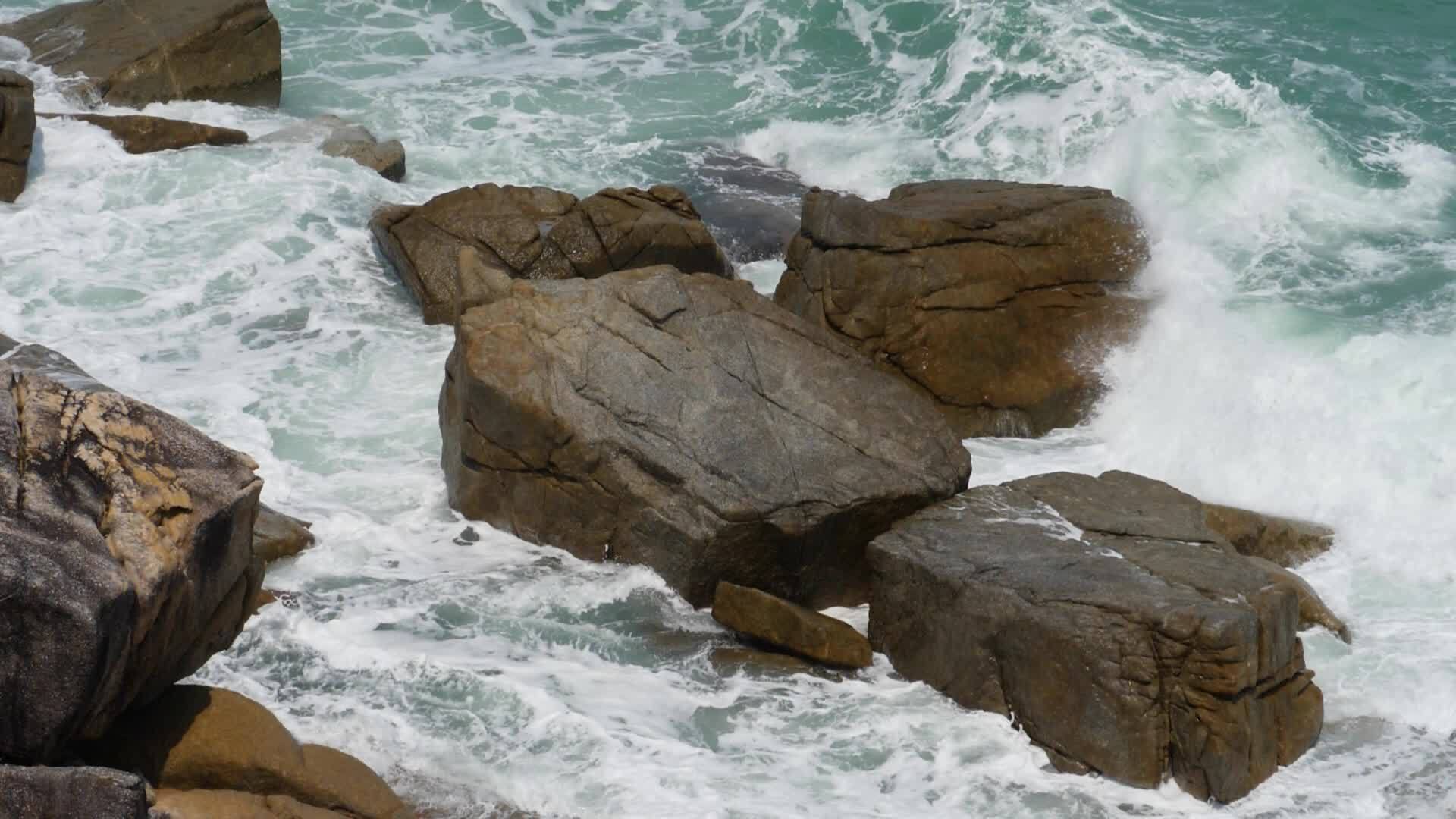 水和巨浪在岩石悬崖上漂浮喷洒白色泡沫视频的预览图