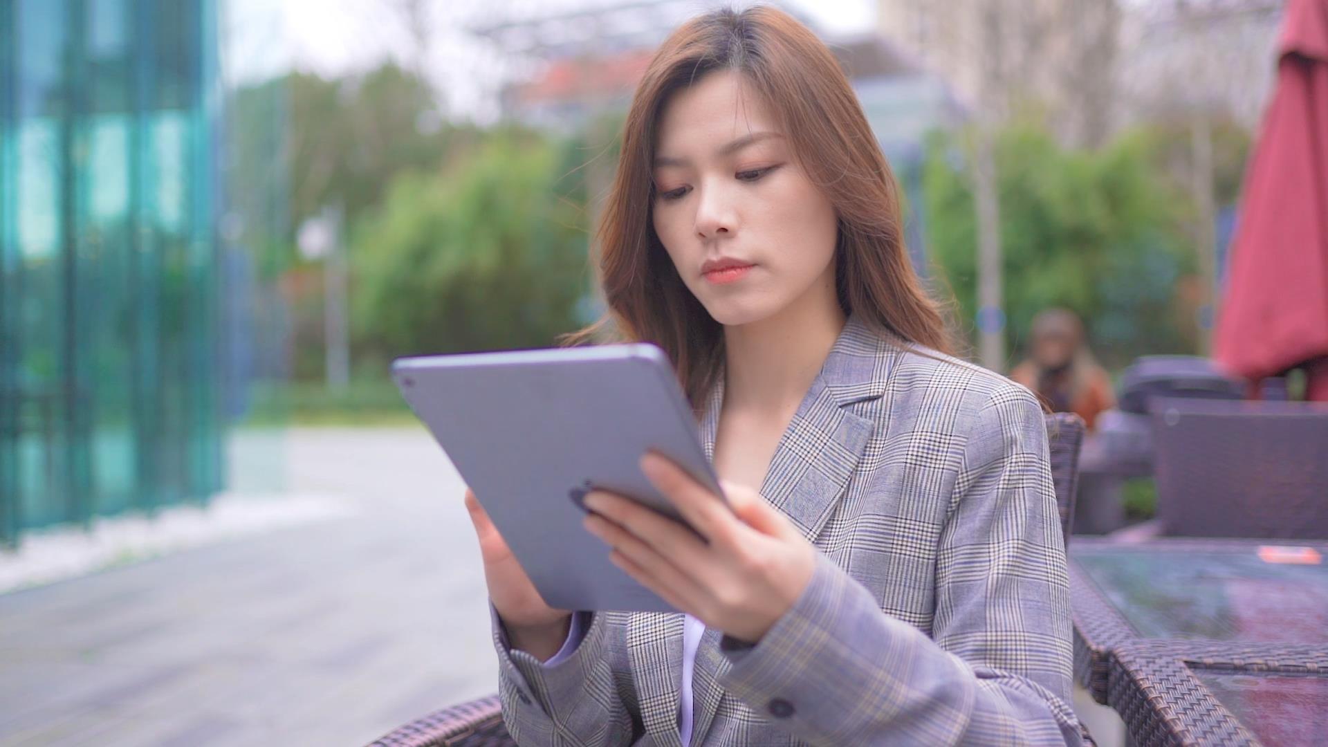 职场女性在户外使用平板视频的预览图