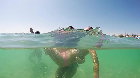 暑假期间两个快乐的女孩姐妹拥抱在水上Gopro视频的预览图
