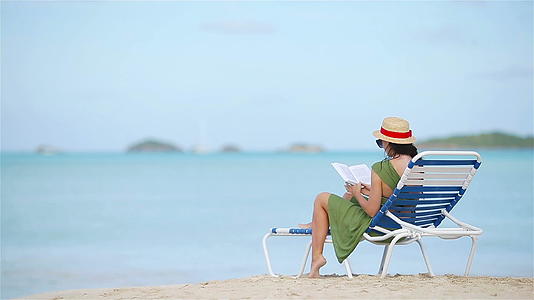 热带白沙滩期间年轻女性阅读书籍和书籍视频的预览图