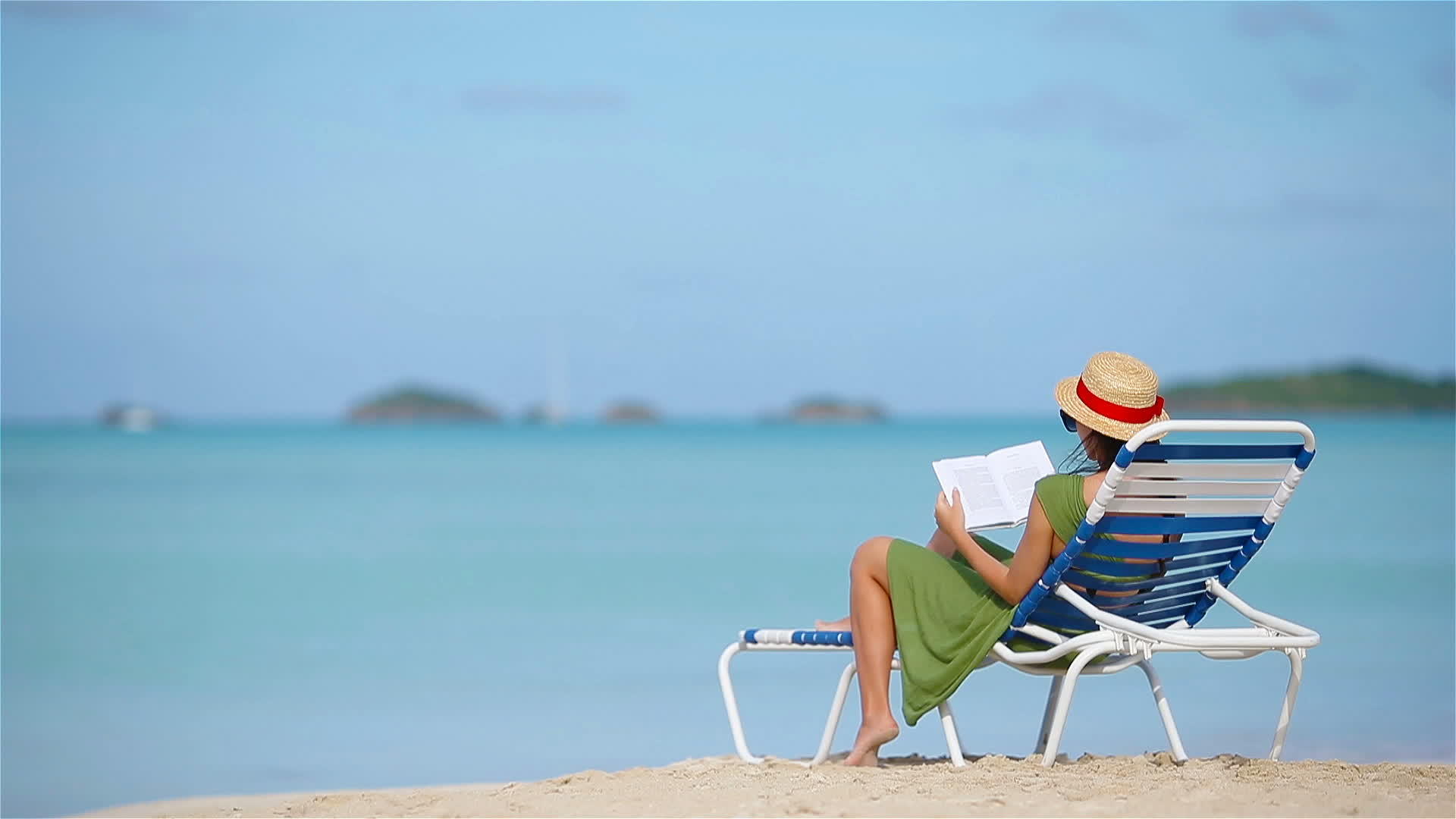年轻女性在热带白色沙滩上阅读关于阳光的书籍视频的预览图