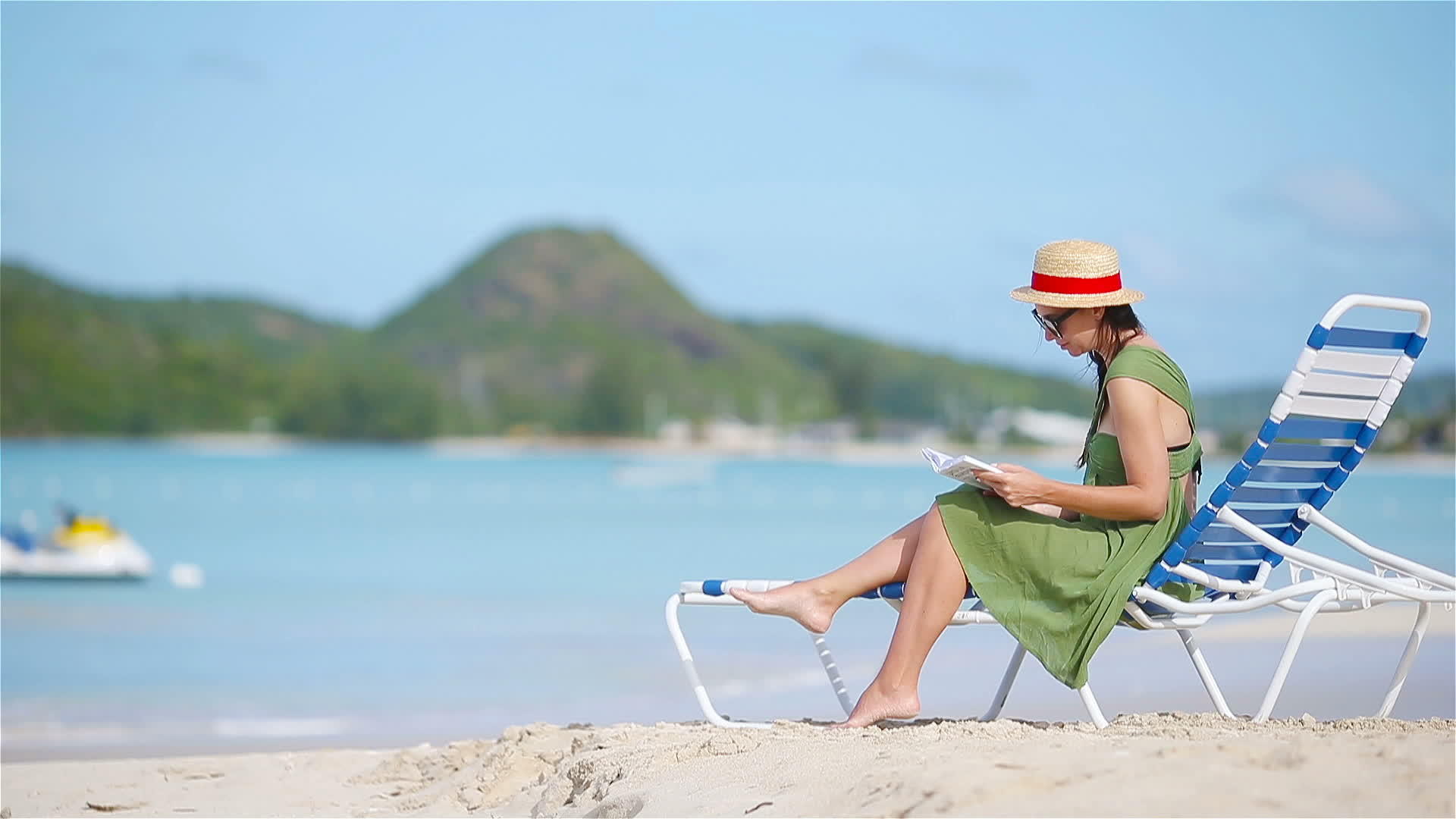 年轻女性在热带白色沙滩上阅读关于阳光的书籍视频的预览图