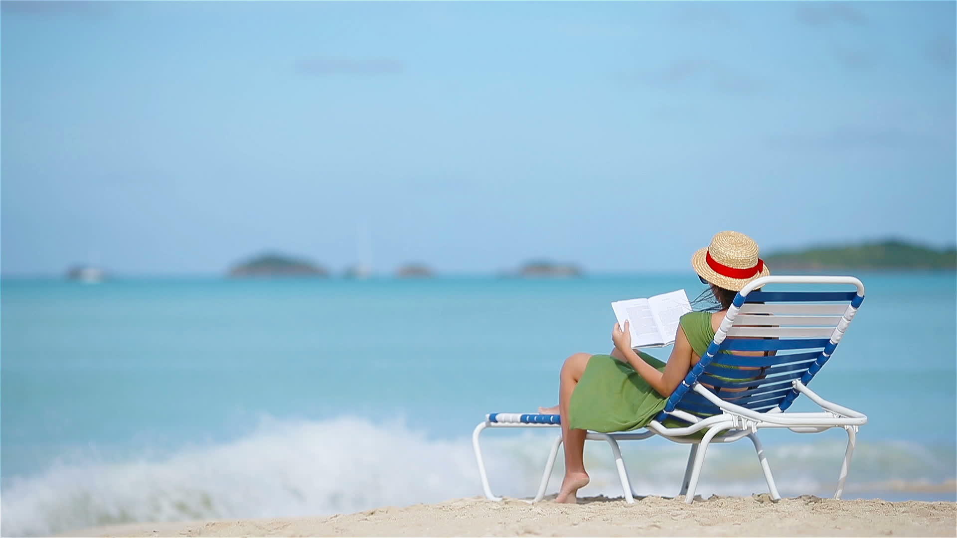 年轻女性在热带白色沙滩上阅读关于彩礼的书籍视频的预览图