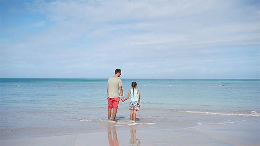 父亲和小女孩的家人在海滩上玩得很开心视频的预览图