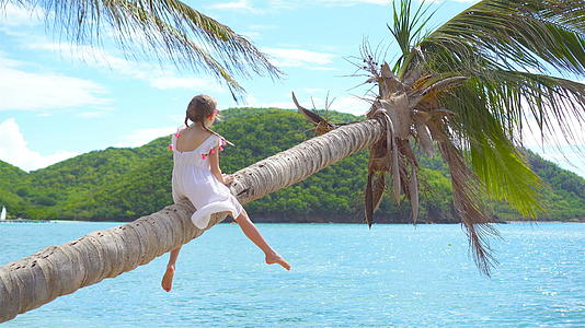 可爱的小女孩暑假期间在棕榈树热带海滩度假视频的预览图