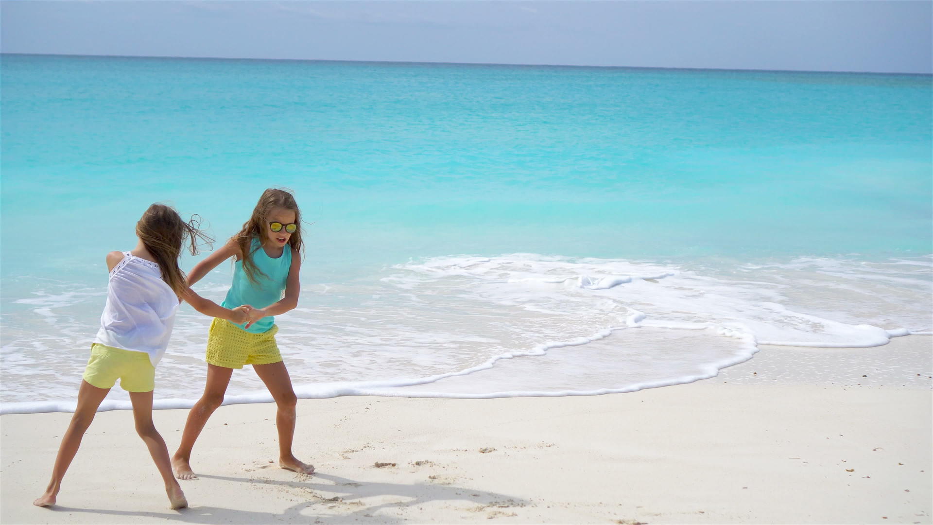 这个可爱的小女孩在白色的热带海滩上玩得很开心视频的预览图