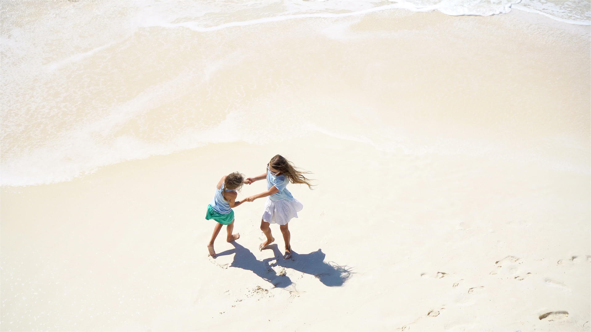 可爱的孩子们一起在浅水海滩上玩耍从沙滩上方看海滩上有绿色视频的预览图