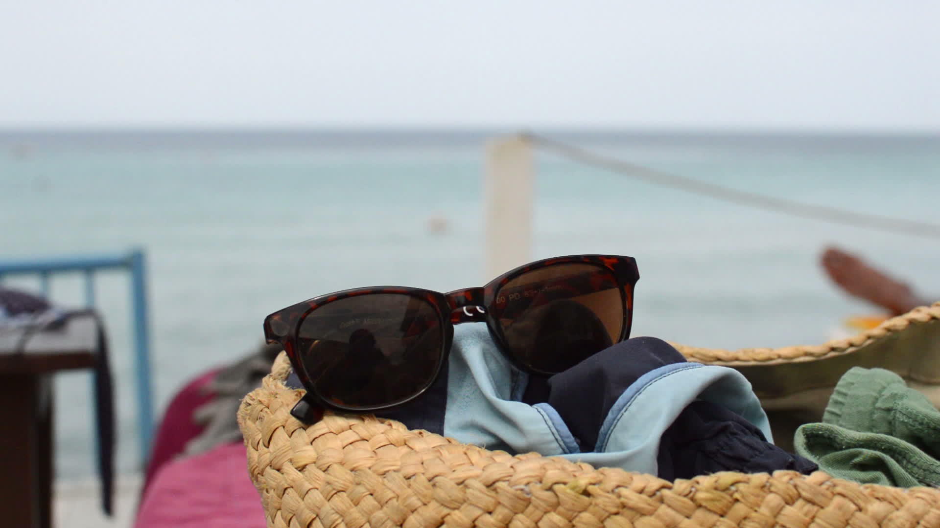 太阳镜放在沙滩上的篮子里视频的预览图