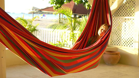 可爱的小女孩在热带度假期间在吊床上放松视频的预览图