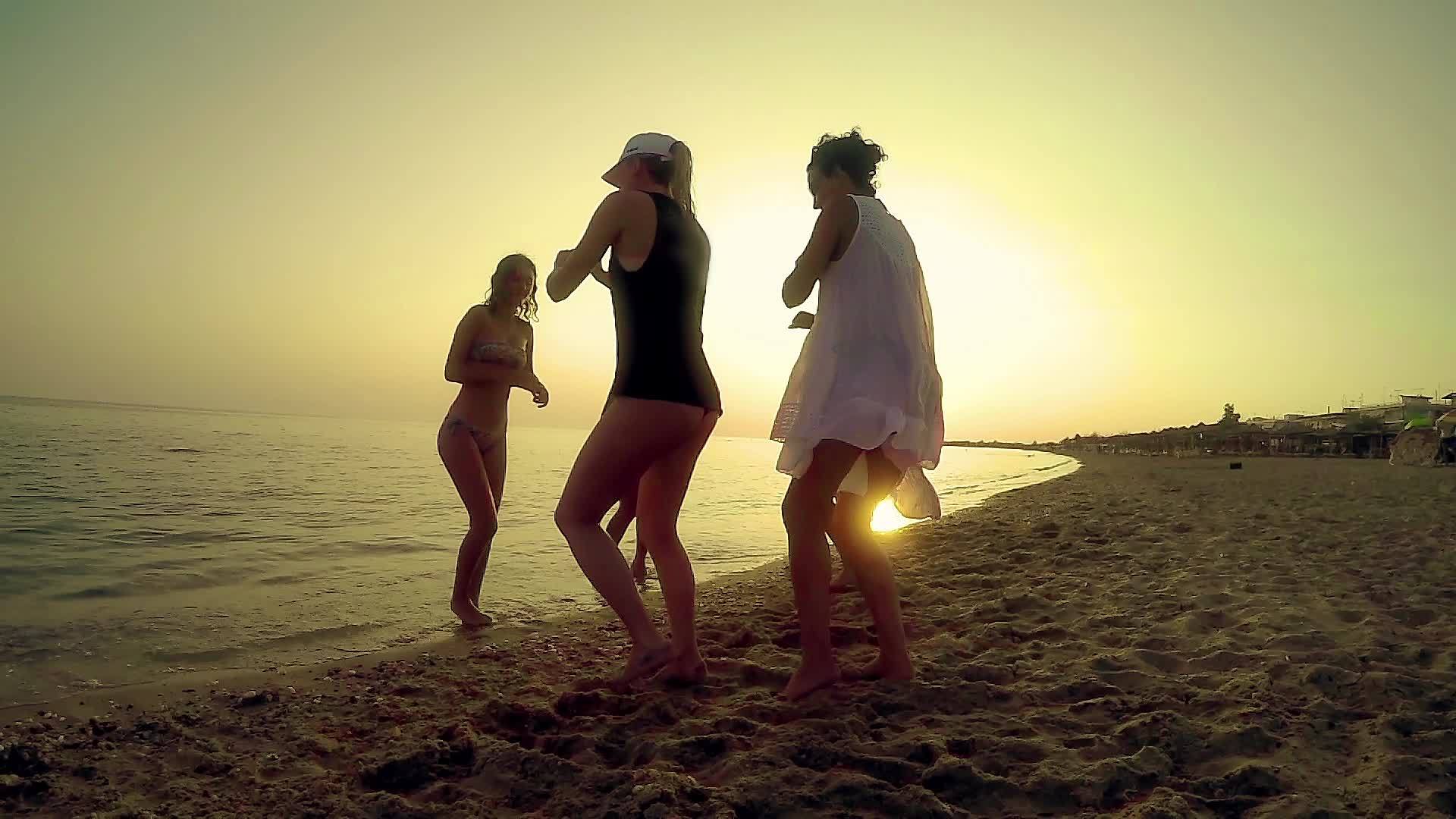 一群快乐的年轻人在海滩上跳舞...在美丽的夏日视频的预览图