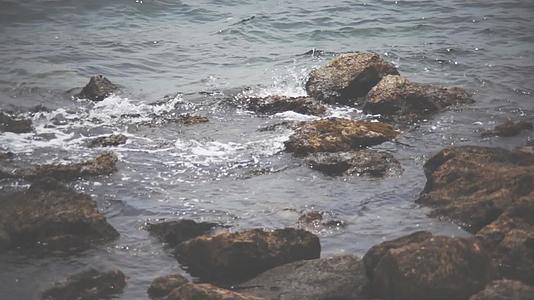 白天一些岩石被反射到海边的水面上视频的预览图
