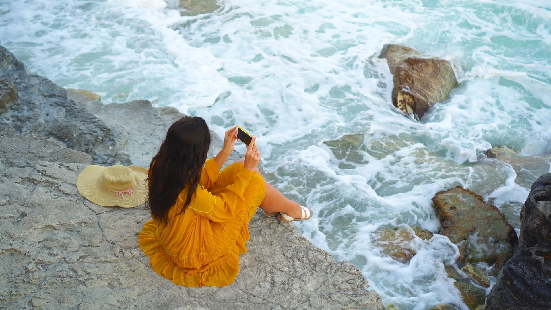 在海边的悬崖上穿着衣服的年轻美女晚上在海滩上快乐的女孩视频的预览图
