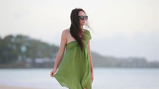 热带海岸的年轻美女在海滩上的绿色蕾丝视频的预览图