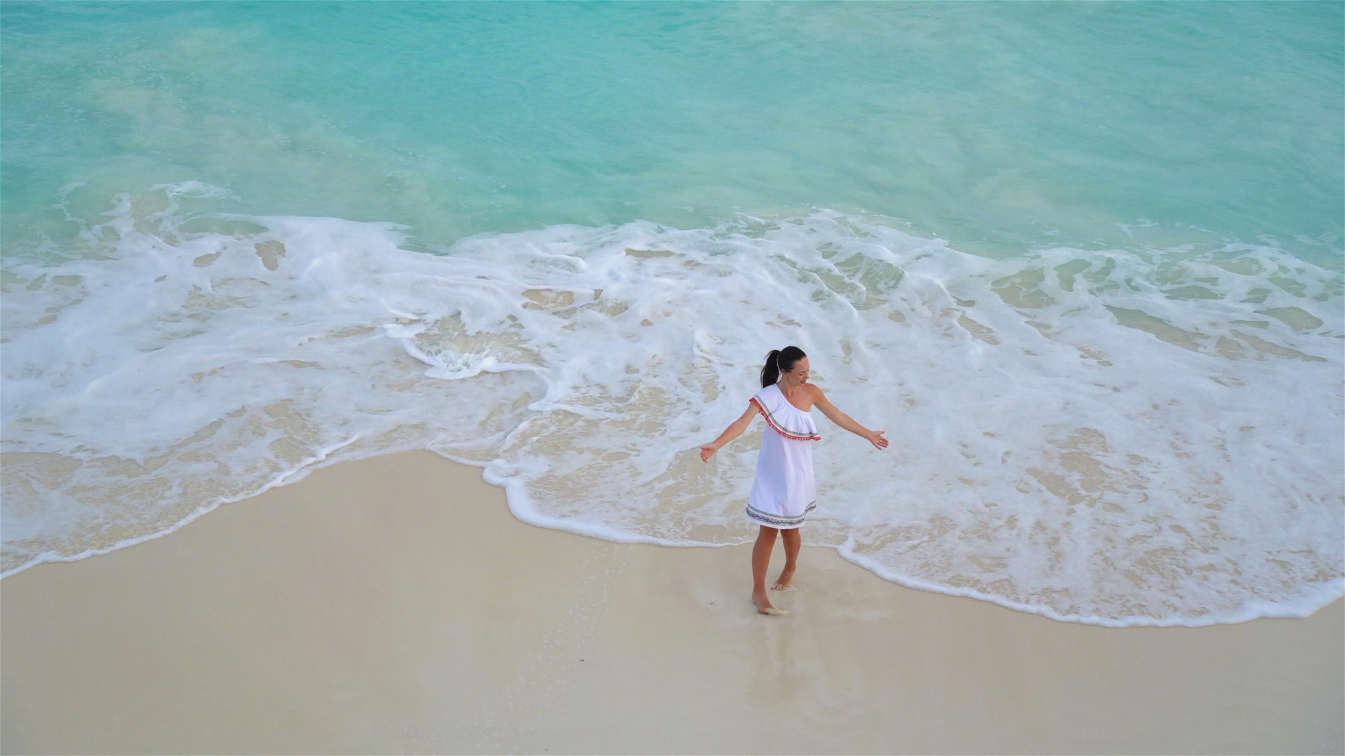 在热带海边的年轻美女面前是一条漂亮的白色沙滩穿着漂亮的裙子视频的预览图