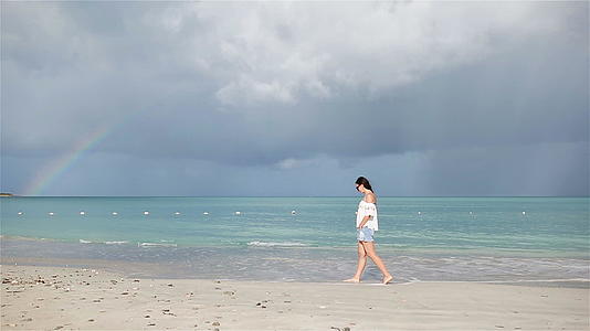 热带海岸的年轻美女快乐的女孩蓝天和海中的绿石水视频的预览图