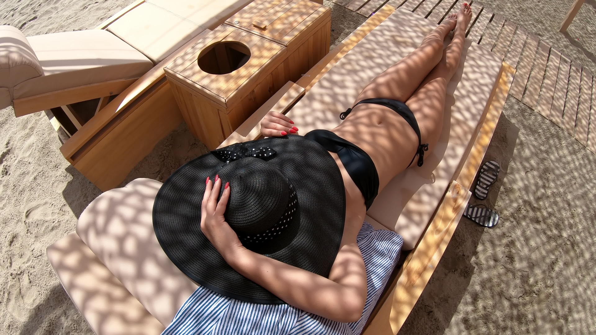 西班牙妇女躺在海滩上放松享受阳光视频的预览图