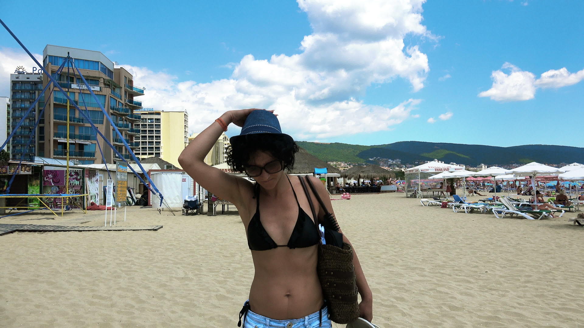 比基尼年轻快乐的女人戴着草帽和太阳镜在海滩上走了四公里视频的预览图