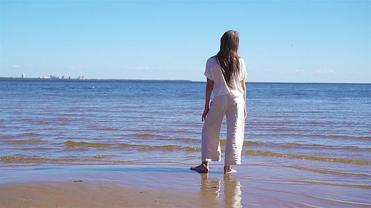 暑假期间可爱的小女孩在海滩上度过暑假视频的预览图