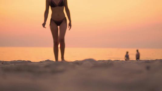 性感女性在海滩上行走在热带海滩日落视频的预览图