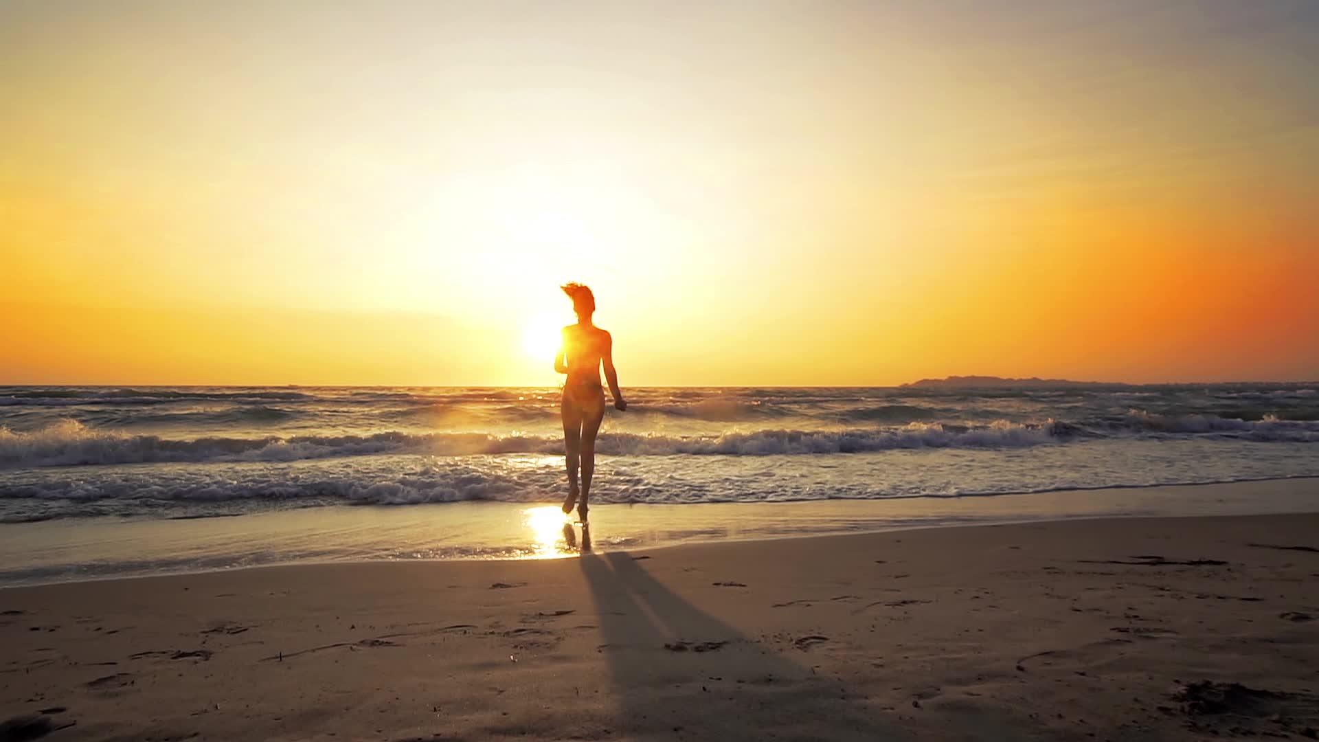 完美的身材性感的性感女人在日落时在海滩上奔跑视频的预览图