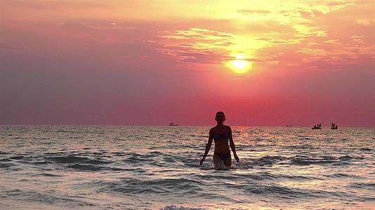 美丽的模特们从日落的海水中出来向着摄像机走去视频的预览图