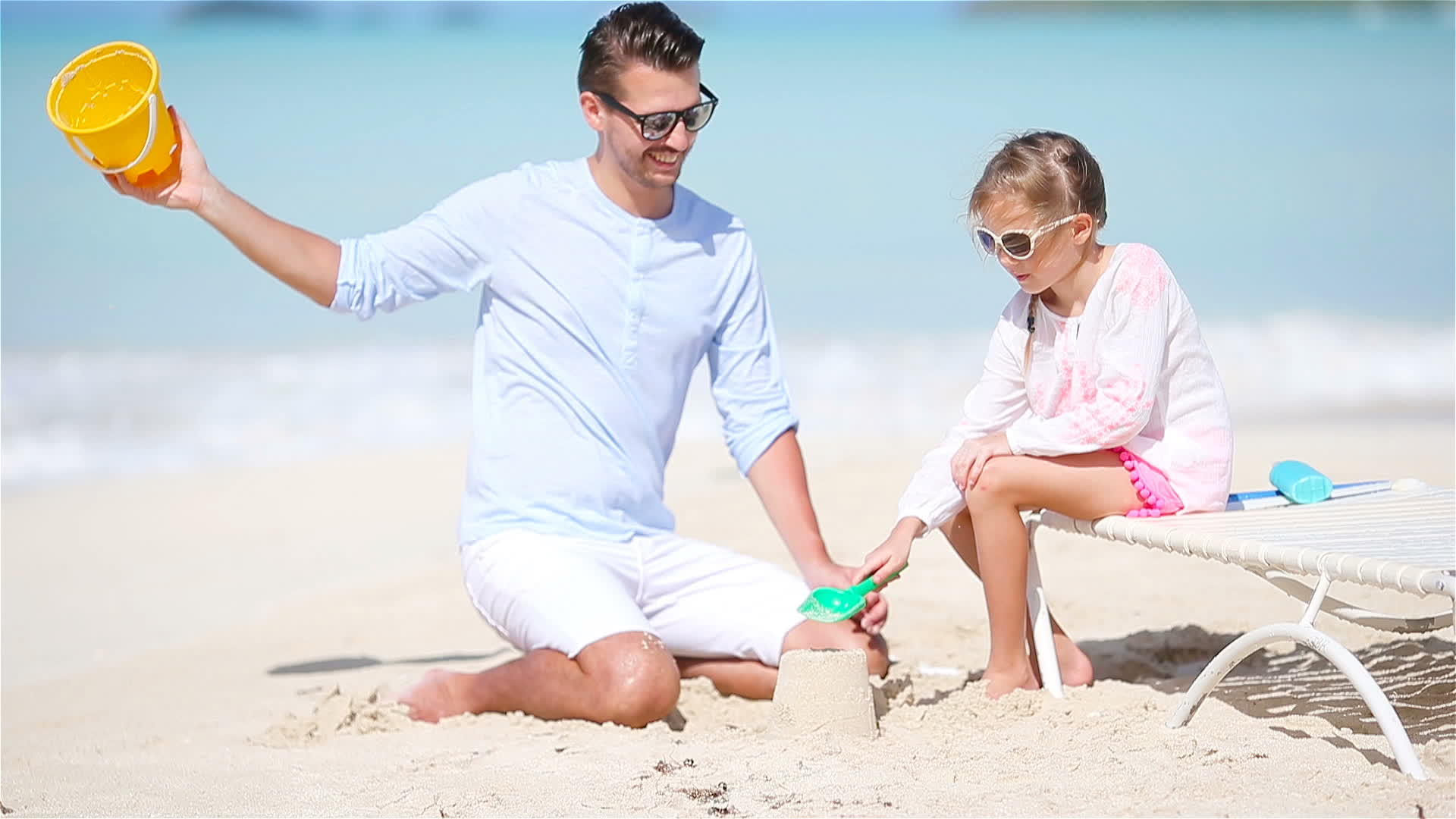 可爱的小女孩在海滩度假时玩玩具孩子们玩沙子视频的预览图