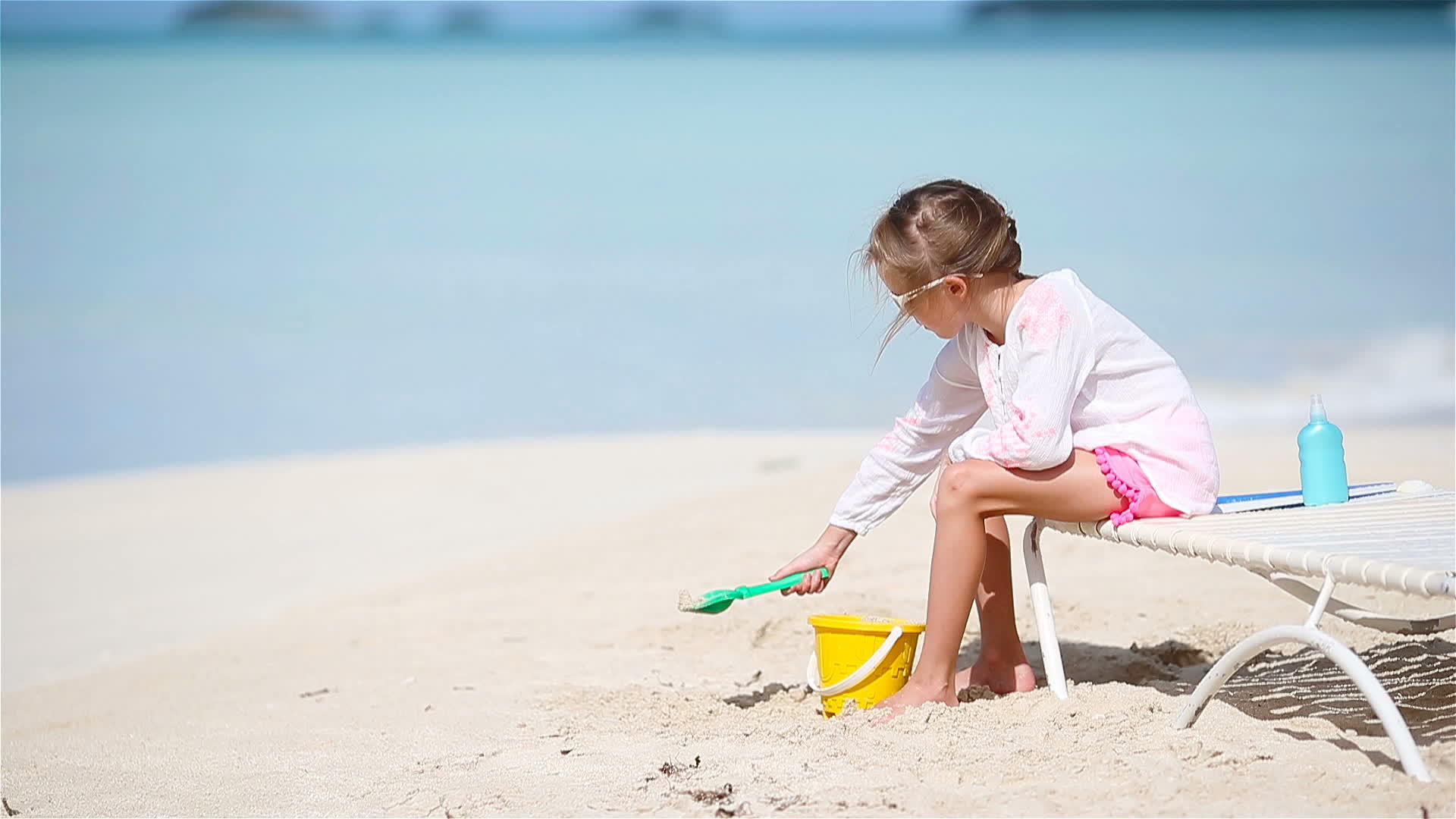 可爱的小女孩在海滩上玩玩具孩子们在阳光下玩沙子视频的预览图