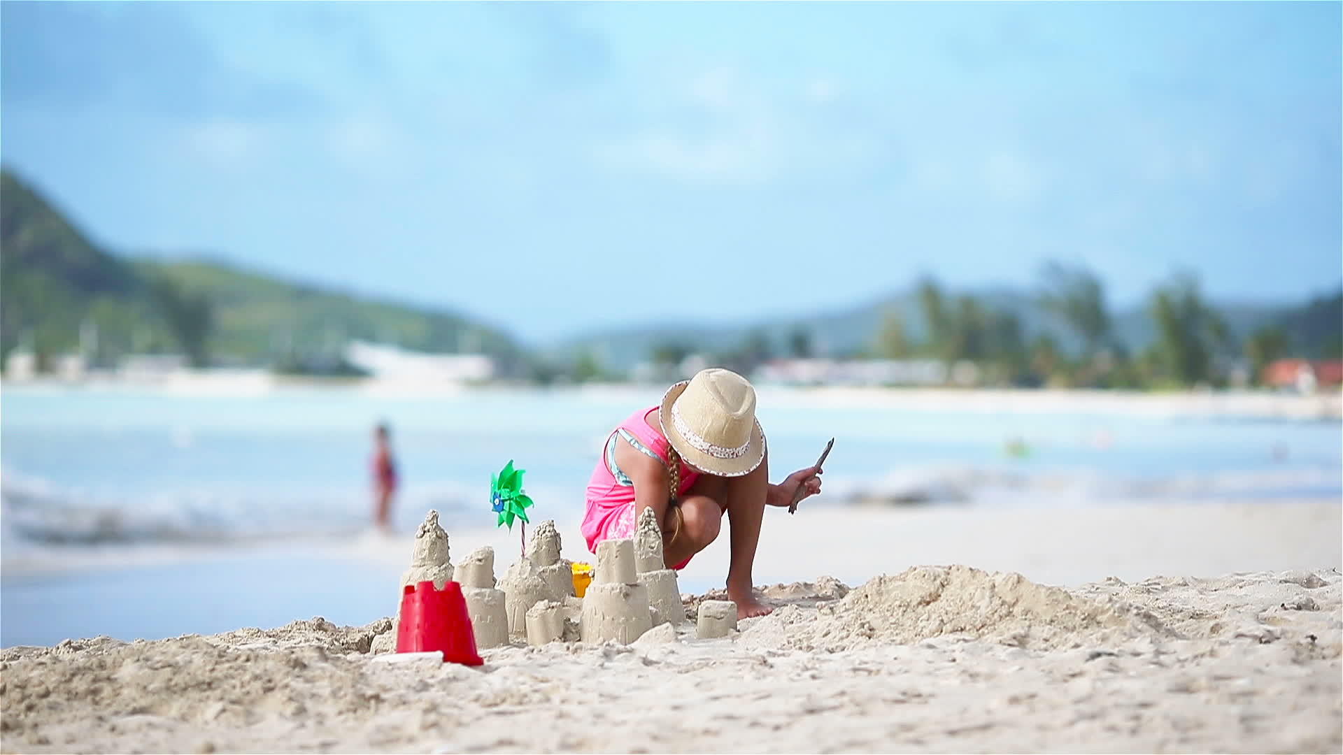 可爱的小女孩在海滩上度假时玩玩具孩子们在海滩上做沙堡视频的预览图