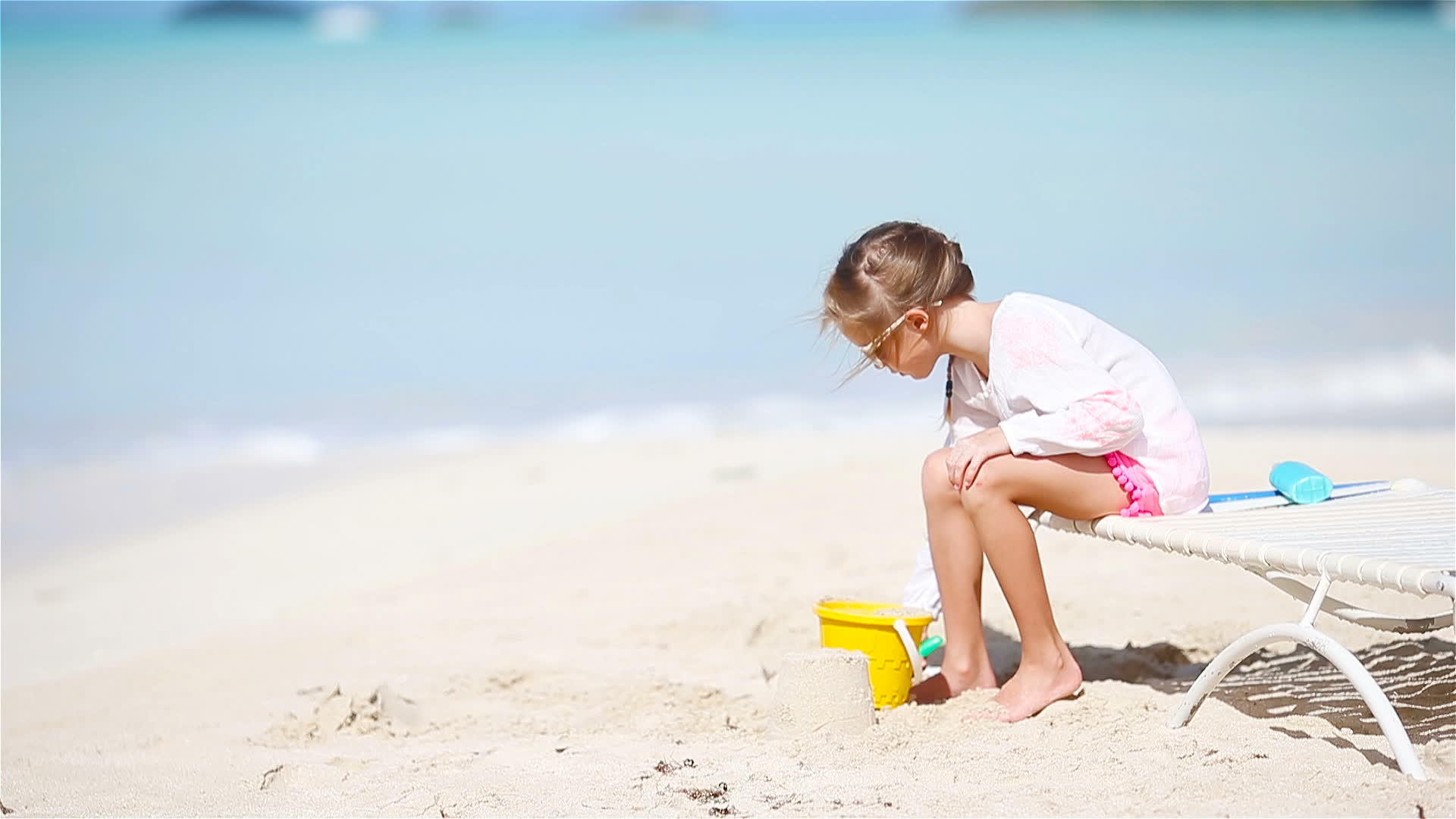 可爱的小女孩在海滩度假时玩玩具孩子们玩沙子视频的预览图