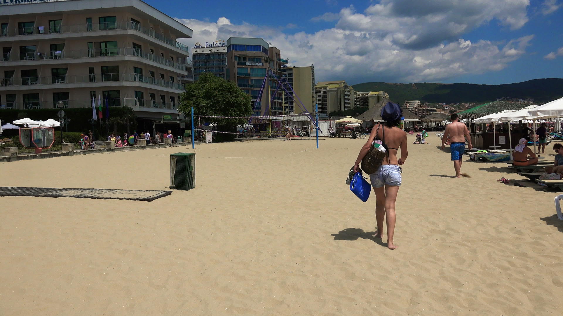 快乐的瘦女人戴着帽子在海滩上散步四公里视频的预览图