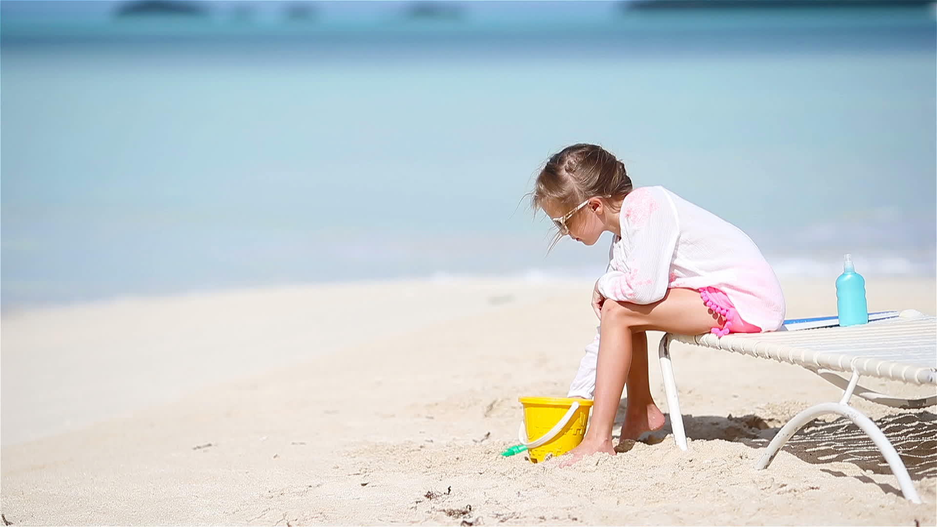 可爱的小女孩在海滩度假时玩玩具视频的预览图
