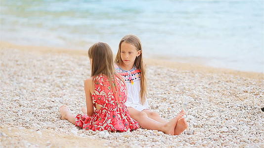 两个快乐的小女孩在热带海滩上玩得很开心视频的预览图