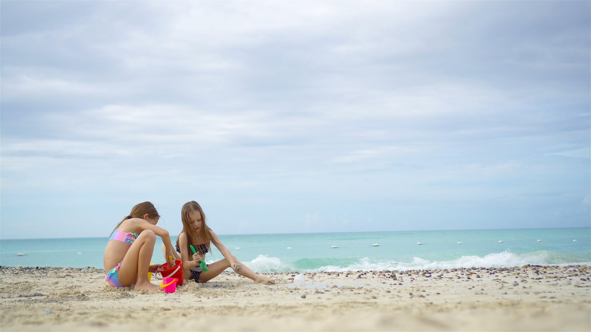 可爱的小女孩暑假在沙滩上玩沙滩玩具视频的预览图