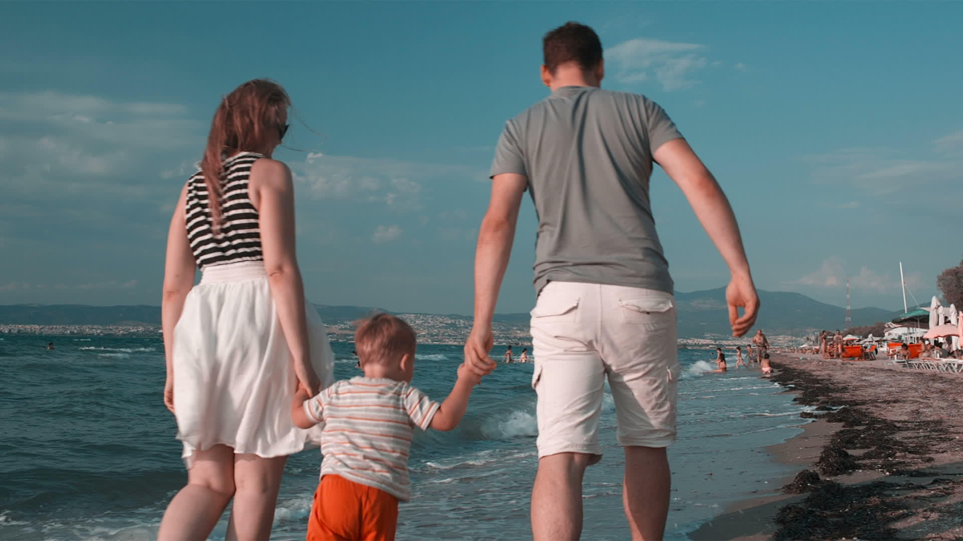 快乐的家庭在夏天在沙滩上行走视频的预览图