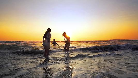 年轻人在日落时跳入大海的休眠电影拍摄对友好家庭的看法视频的预览图