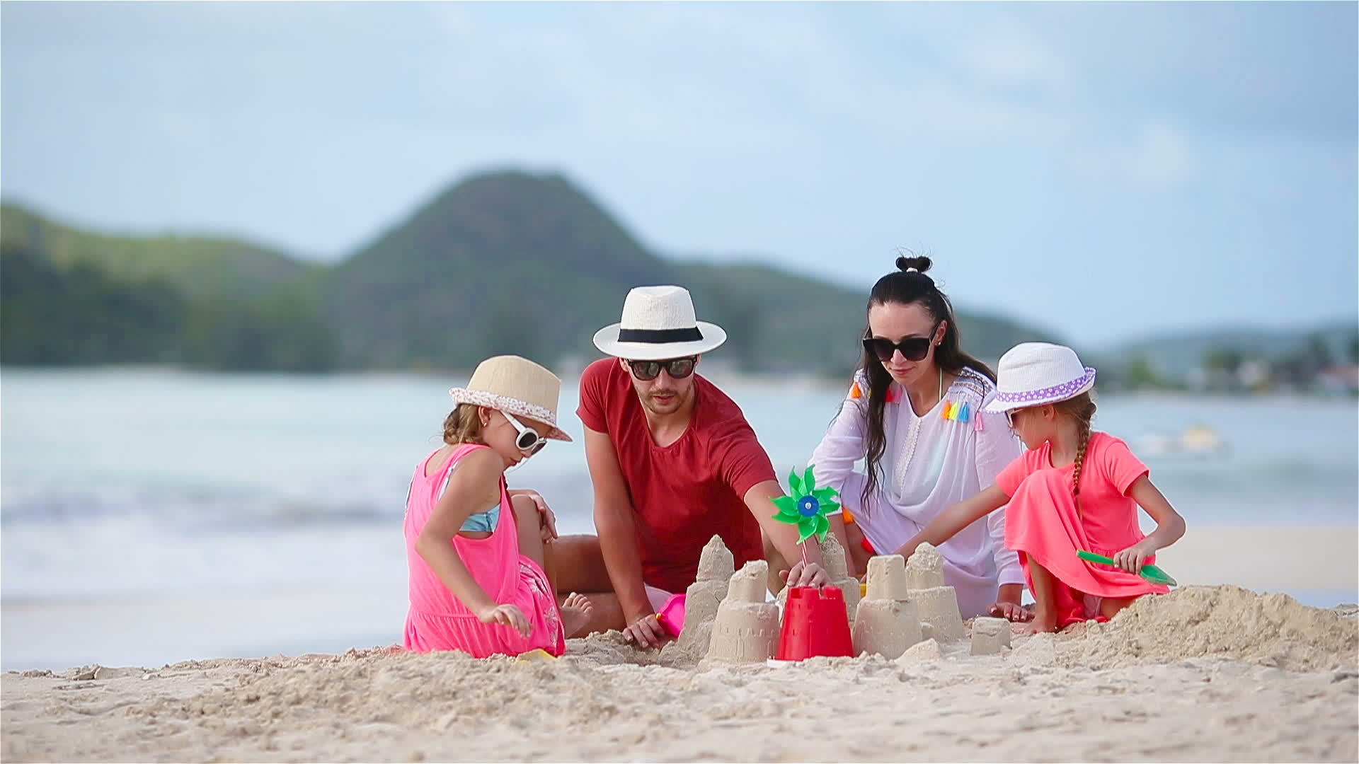 家庭在热带白色海滩建造海滩城堡视频的预览图