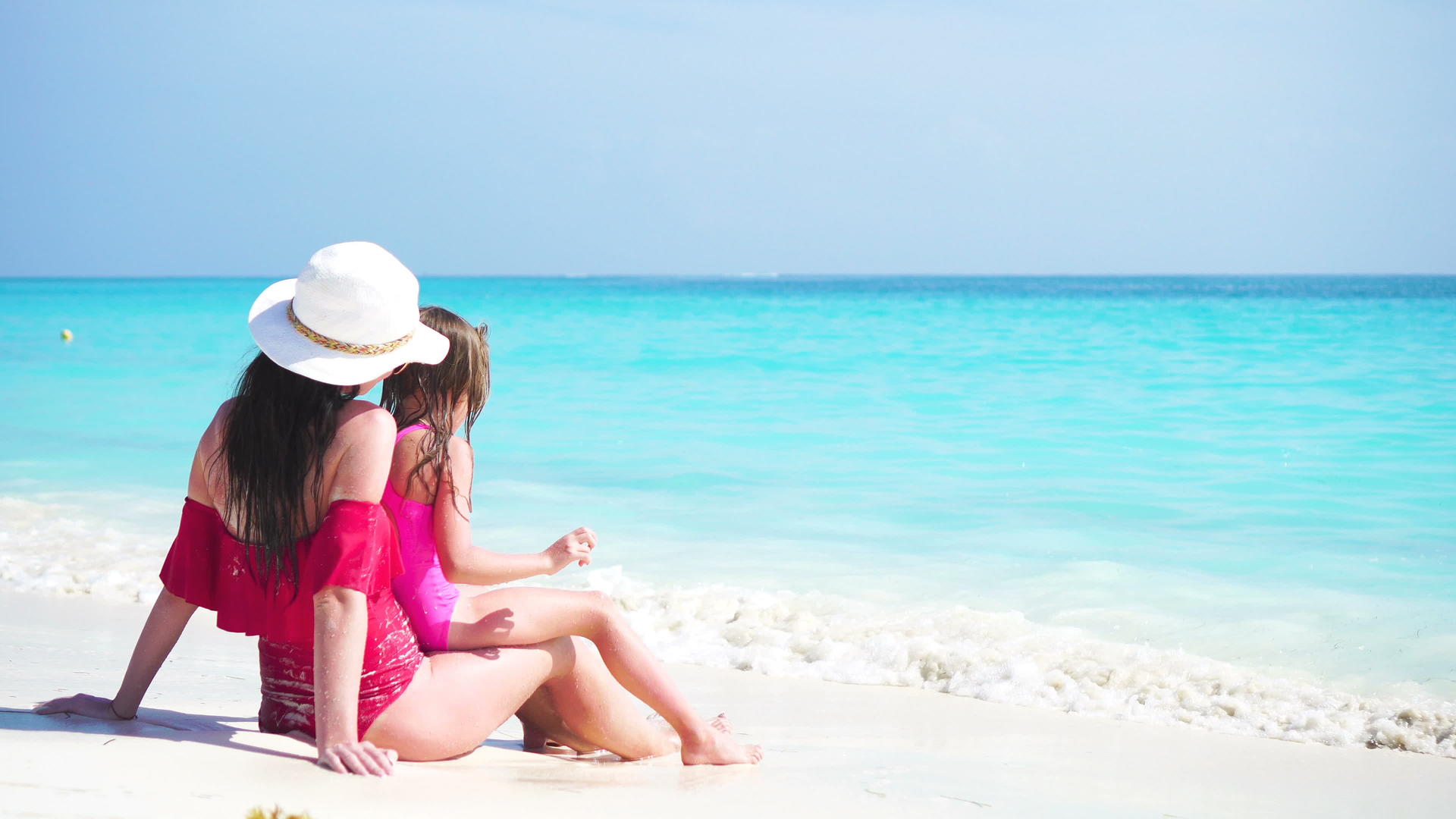 可爱的小女孩和年轻的母亲在热带海滩上享受海上度假视频的预览图