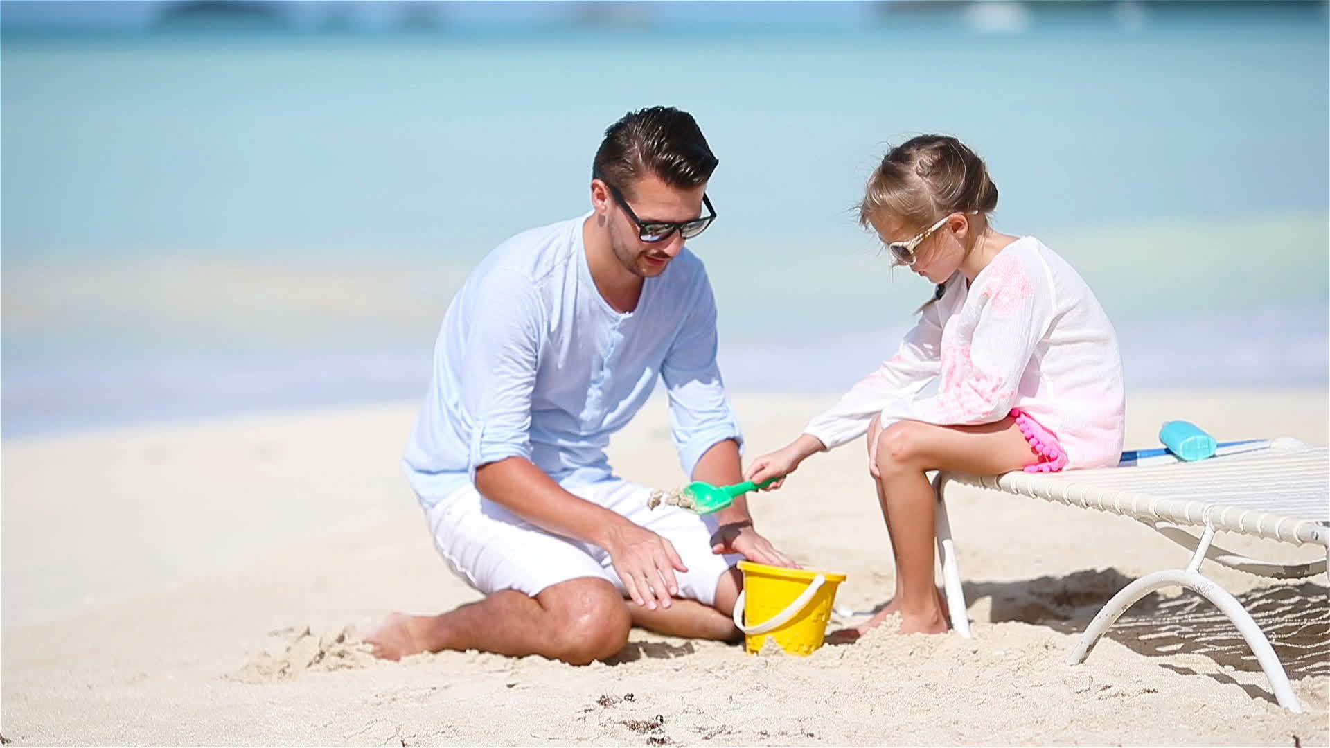 父亲和可爱的小可爱女孩在热带海滩制造沙堡视频的预览图